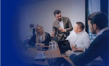 Mann im Hemd sitzt vor seinem Labotop. Hält sein Nasenbein runzelt die Stirn