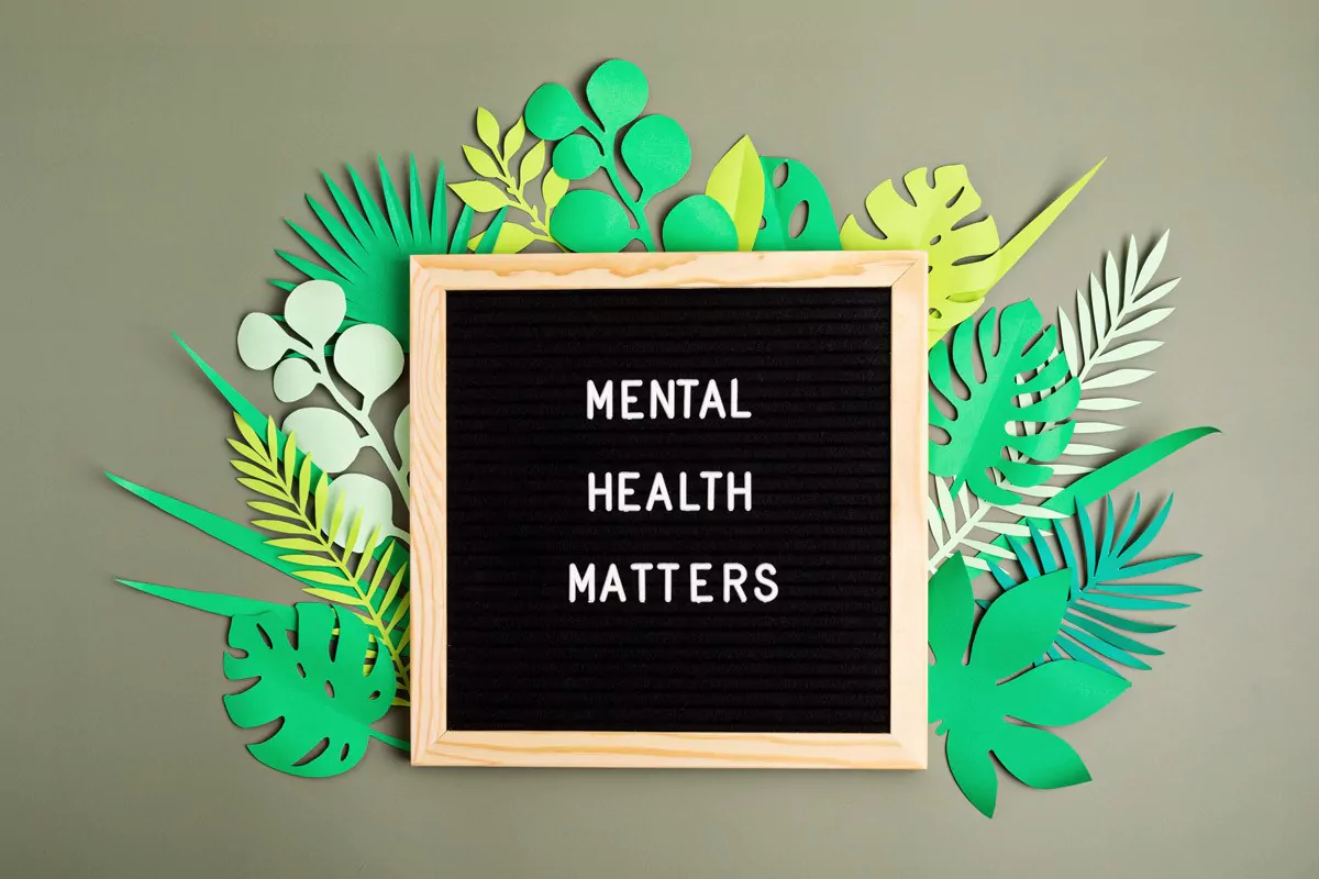 Fairfamily_Mental_Health_Matters Eine Hand hält eine Spielfigur und mehrere Figuren stehen drumherum