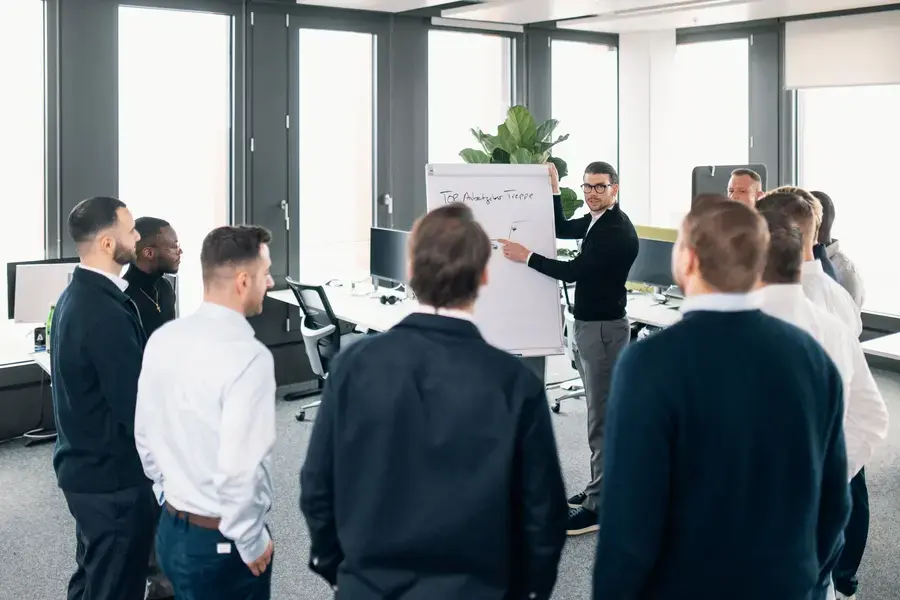 Partizipativer Führungsstil: Führungskraft diskutiert mit Team auf Augenhöhe in einem Workshop.